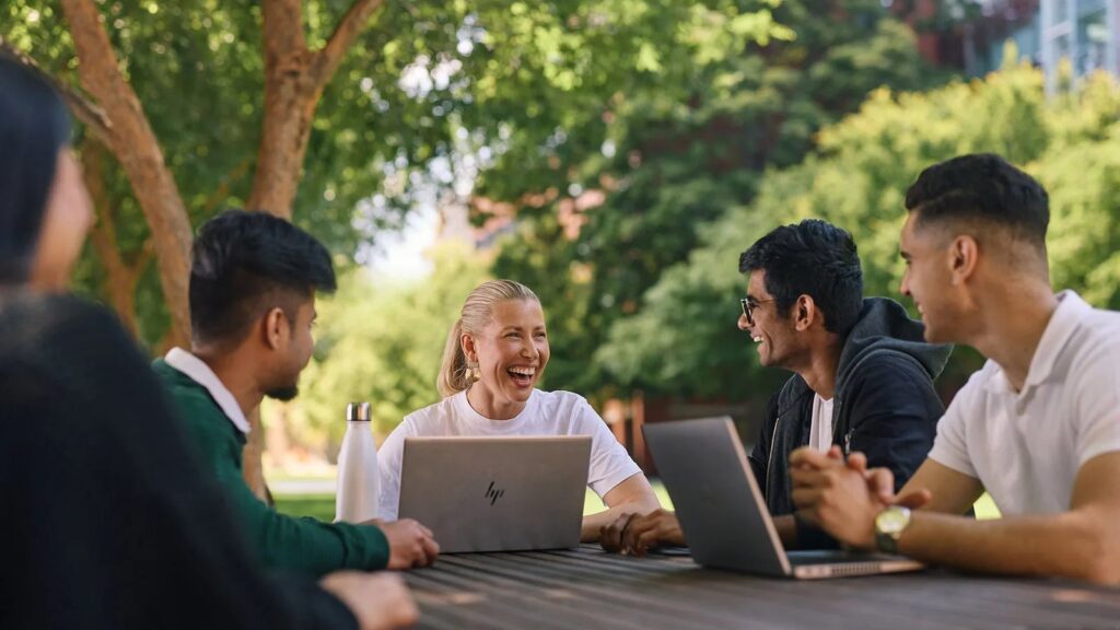 Staff working together on laptops at an outdoor table